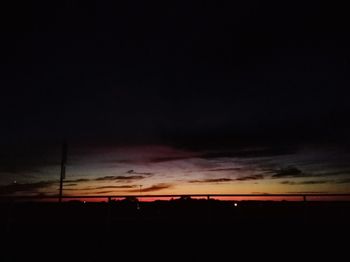 Silhouette landscape against dramatic sky during sunset