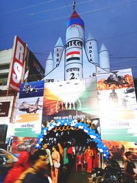 People on street against buildings in city
