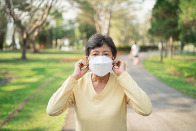 Portrait of woman wearing mask at park