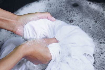 High angle view of hands holding white fabric