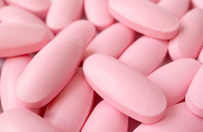 Closeup heap of pink supplement pills for he concept of beauty and healthcare