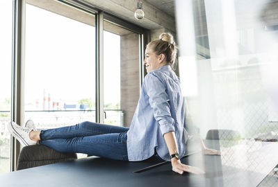 Young businesswoman sitting on desk