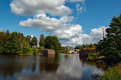 Scenic view of river by trees against sky