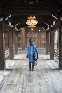 Rear view of woman walking in building