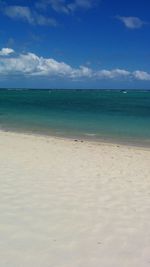 Scenic view of beach against blue sky