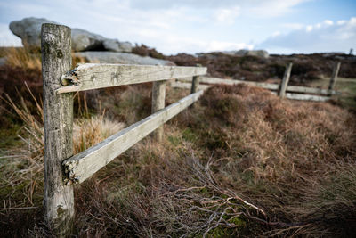 Wooden fence on field against sky