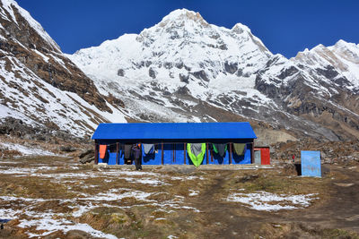 Built structure on snowcapped mountain against blue sky