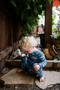 Cute boy looking at while sitting outdoors