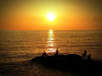 Silhouette people at beach during sunset