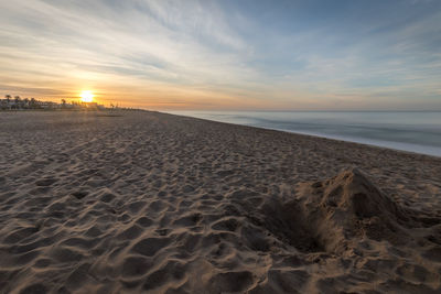 Scenic view of beach against sky during dawn