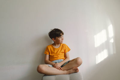 Cute boy sitting barefoot in a home. beautiful light.