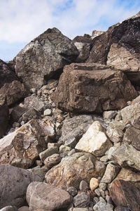 Low angle view of rocks on mountain against sky