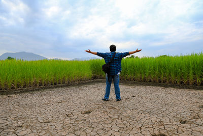Man standing on field against sky