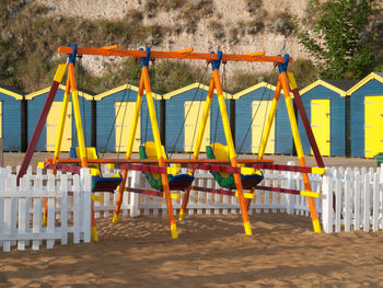 Empty chairs on beach against sky