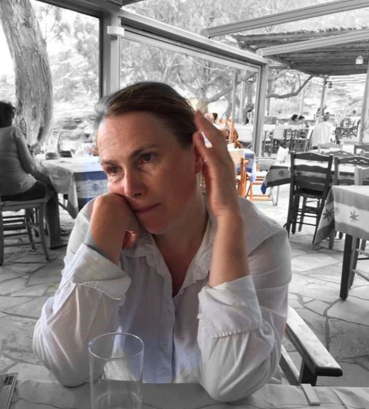 PORTRAIT OF A YOUNG WOMAN SITTING AT RESTAURANT