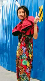 Young woman standing against the wall
