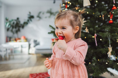 Young woman blowing bubbles while standing against trees