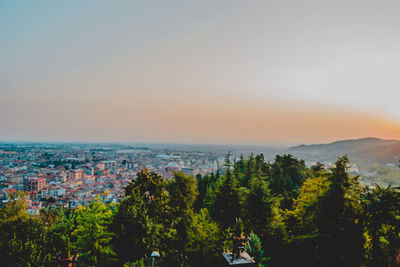 High angle view of trees and buildings against sky during sunset