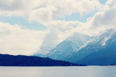 Snow covered mountains against cloudy sky