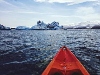 Scenic view of iceberg floating on water against sky