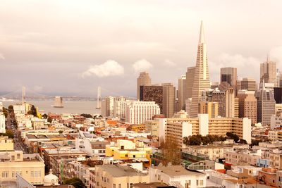 High angle view of buildings in city against cloudy sky