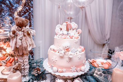 Three-tiered cake decorated with meringue, caramel bear, ginger one 