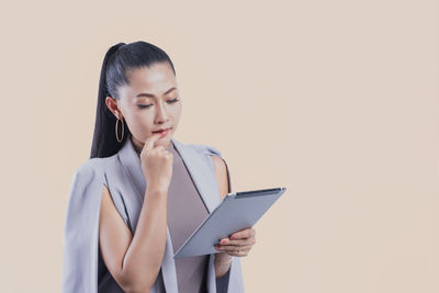 Young woman looking away against white background