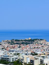 High angle view of town by sea against clear sky