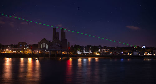 Illuminated buildings at waterfront during night