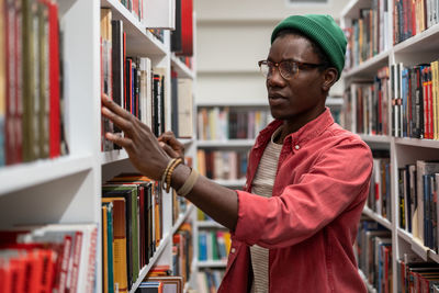 Portrait of young woman standing in library