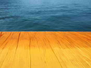 High angle view of yellow wood against sea