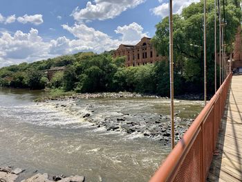 Scenic view of river by building against sky