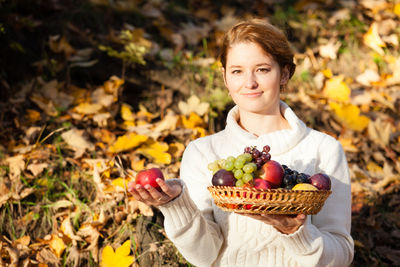 Woman holding fruit basket outdoors