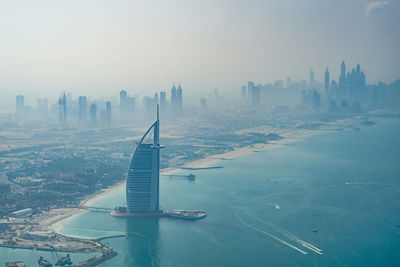 Aerial view of buildings in city against sky