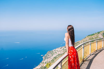 Rear view of woman looking at sea against sky