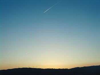 Silhouette field against sky during sunset