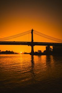 Silhouette of suspension bridge at sunset