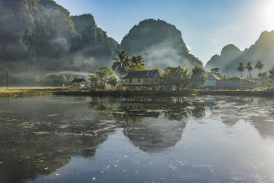 Scenic view of lake by buildings against sky