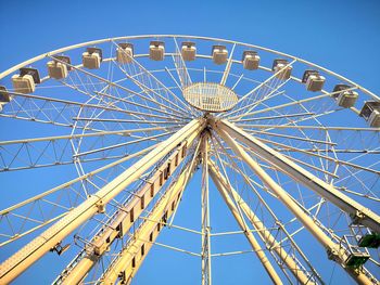 Low angle view of ferris wheel against blue sky