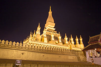 Low angle view of illuminated building against sky at night