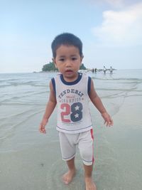 Portrait of boy on beach against sky