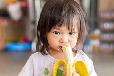 Portrait of cute girl eating banana