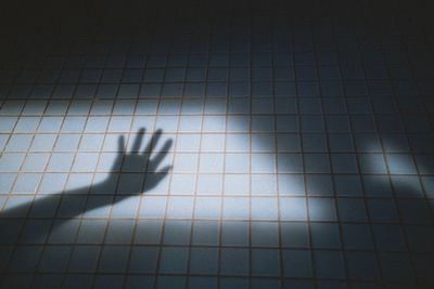 High angle view of shadow on tiled floor