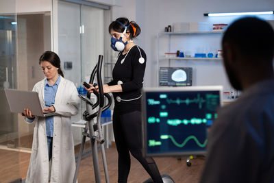 Doctor examining female athlete in clinic