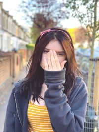 Portrait of teenage girl covering face