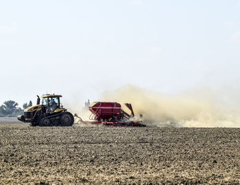 Tractor on field against clear sky