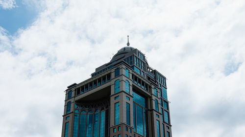 Low angle view of buildings against cloudy sky