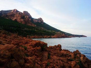 Scenic view of sea and mountains against sky