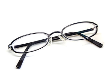 Close-up of eyeglasses on glass against white background