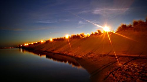 Scenic view of calm river at sunset